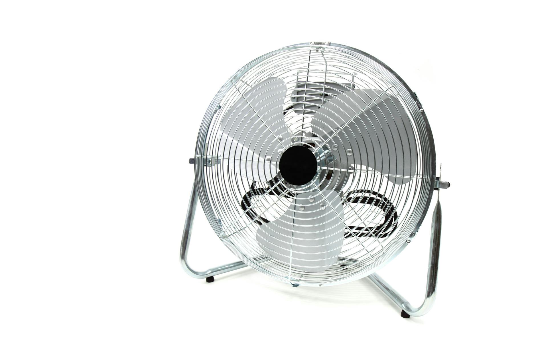 Sleek stainless steel industrial floor fan with metal blades isolated on white.