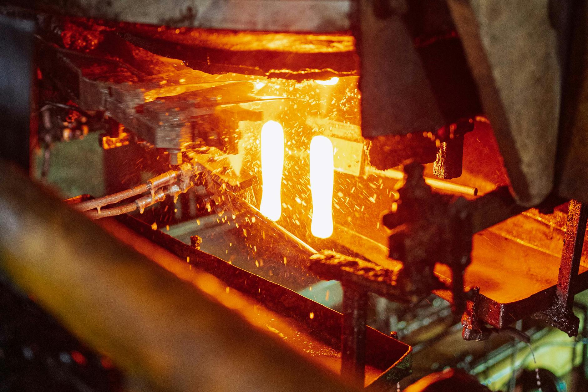 Glassblowing process in a Tanzanian factory showcasing molten glass formation.